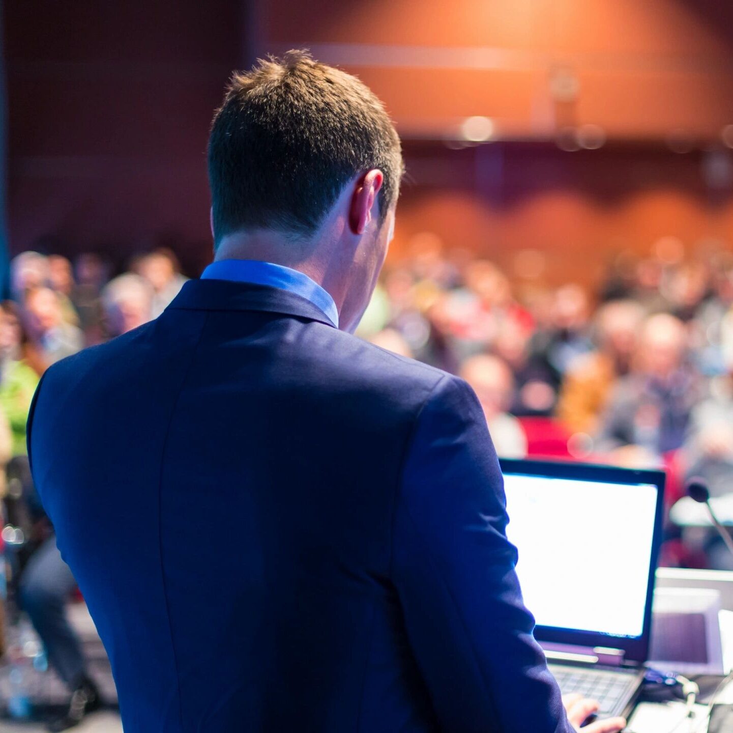 Speaker at a podium addresses an audience